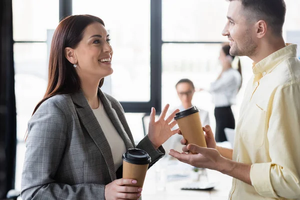 Gente alegre de negocios con café hablando en la oficina - foto de stock