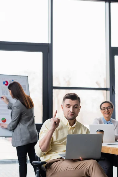 Homme d'affaires avec ordinateur portable ayant une idée dans le bureau — Photo de stock