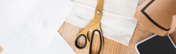 Top view of sketch near smartphone, scissors and cloth, banner — Stock Photo