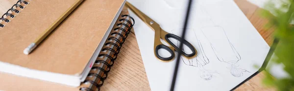 Scissors near sketches and notebooks on table, banner — Stock Photo