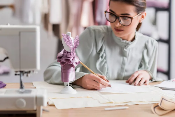 Mannequin near sewing machine and blurred designer — Stock Photo