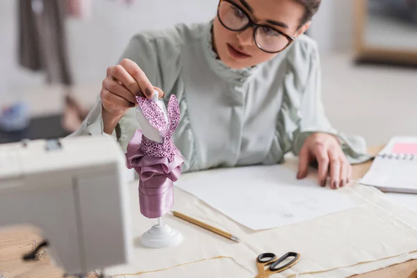 Mannequin avec robe près concepteur flou et tissu sur la table — Photo de stock