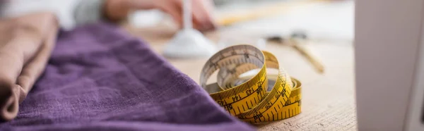 Measuring tape and cloth on table, banner — Stock Photo