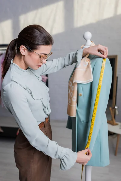 Manga de medición costurera de la chaqueta en el maniquí - foto de stock