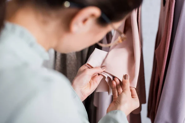 Verschwommene Näherin betrachtet Kleidungsärmel im Atelier — Stockfoto