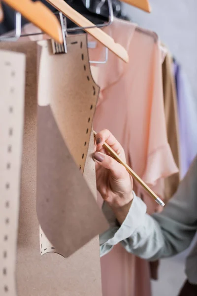 Vue recadrée du designer avec des motifs de couture touchants au crayon — Photo de stock