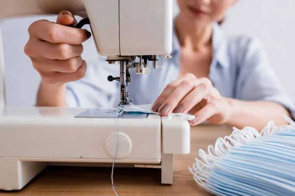 Vista recortada de costurera costura máscara médica en la máquina - foto de stock