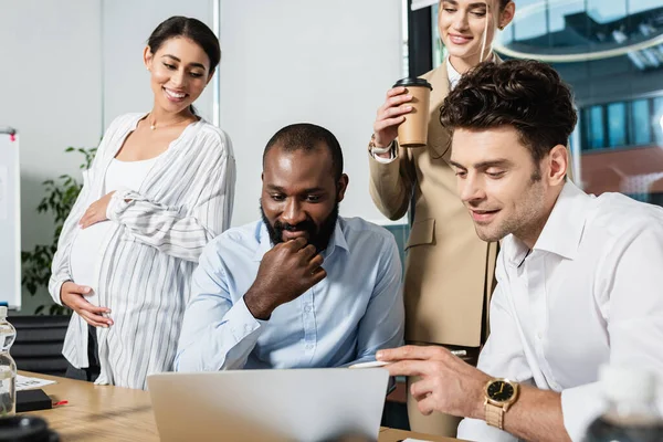 Glückliche multikulturelle Geschäftsleute, die im Konferenzraum auf Laptop schauen — Stockfoto