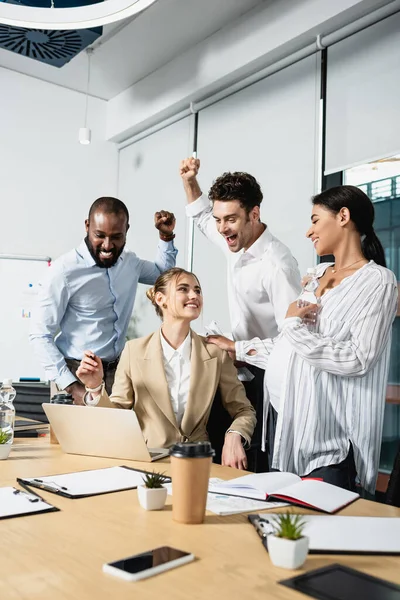 Successful multiethnic businesspeople showing win gesture during meeting — Stock Photo