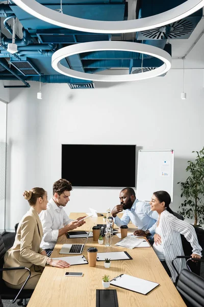 Equipe de negócios interracial conversando durante reunião na sala de conferência — Fotografia de Stock