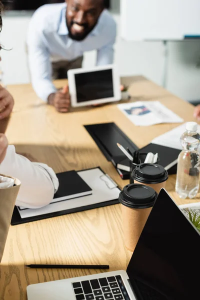 Blurred african american businessman showing digital tablet with blank screen during meeting — Stock Photo