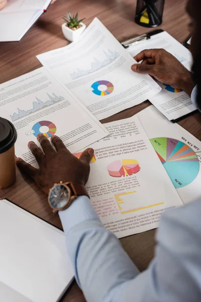 Cropped view of african american businessman working with infographics — Stock Photo