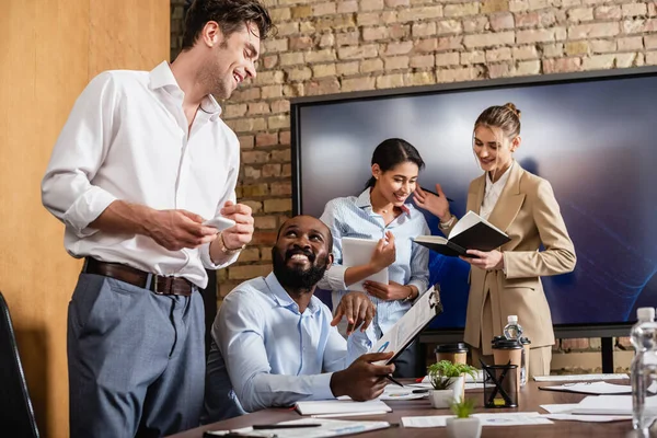 Positive interracial businesspeople talking in conference room — Stock Photo