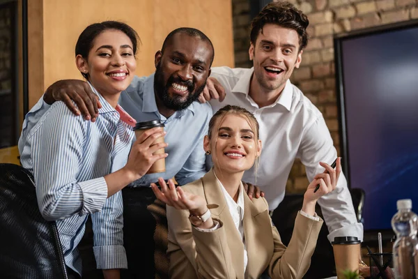 Glückliche multiethnische Geschäftspartner lächeln im Konferenzraum in die Kamera — Stockfoto