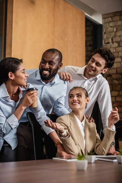 Cheerful interracial business colleagues talking in conference room — Stock Photo