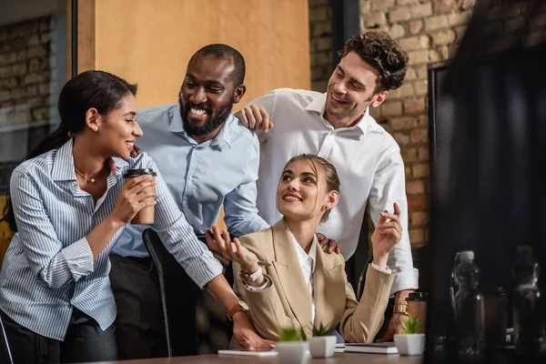 Fröhliche multikulturelle Geschäftsleute reden im Konferenzraum über verschwommenen Vordergrund — Stockfoto