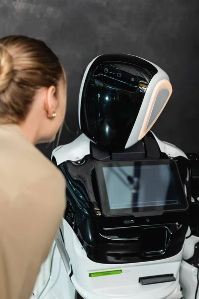 Young businesswoman near humanoid robot in office — Stock Photo