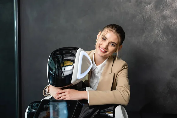 Donna d'affari sorridente alla macchina fotografica mentre abbraccia robot in ufficio — Foto stock