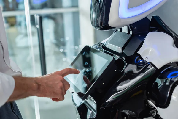 Cropped view of businessman operating robot in office — Stock Photo