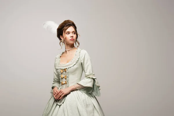 Jovem mulher em elegante vestido retro olhando para longe isolado em cinza — Fotografia de Stock