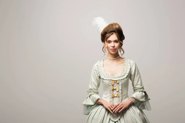 Mulher sorridente em vestido vintage elegante olhando para a câmera isolada em cinza — Stock Photo