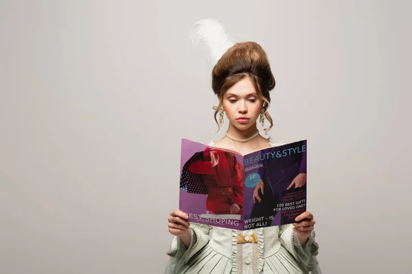 Pretty woman in stylish vintage outfit reading modern magazine isolated on grey — Stock Photo