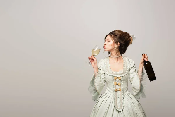 Elegant woman in retro dress drinking white wine isolated on grey — Stock Photo