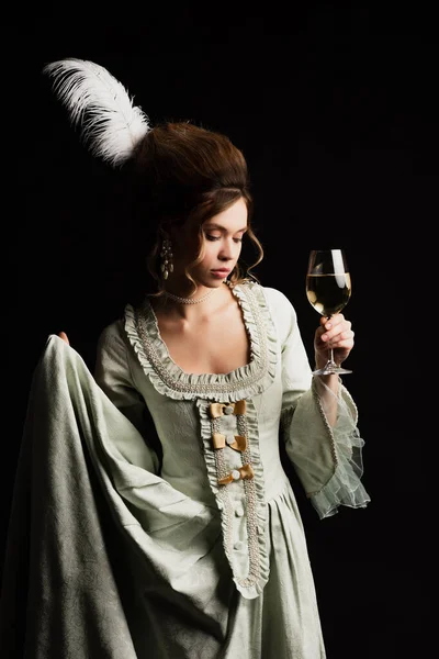 Femme élégante en robe rétro posant avec verre de vin blanc isolé sur noir — Photo de stock