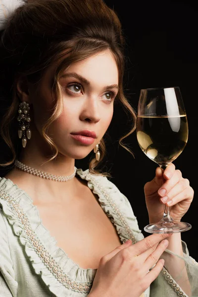 Charmante femme en tenue vintage élégante tenant verre de vin blanc isolé sur noir — Photo de stock