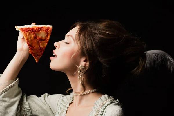 Sensual mulher estilo vintage com olhos fechados segurando deliciosa pizza isolada em preto — Fotografia de Stock