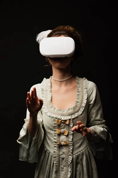 Винтажный стиль женщина в пастель серый платье игры в VR гарнитуры изолированы на черный — стоковое фото
