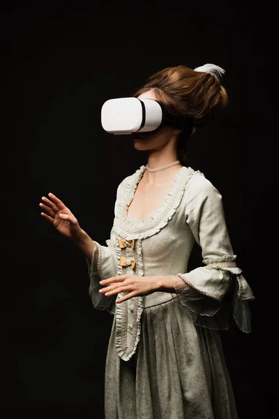 Vintage-Stil Frau in pastellgrauem Kleid Gaming in vr Headset isoliert auf schwarz — Stockfoto