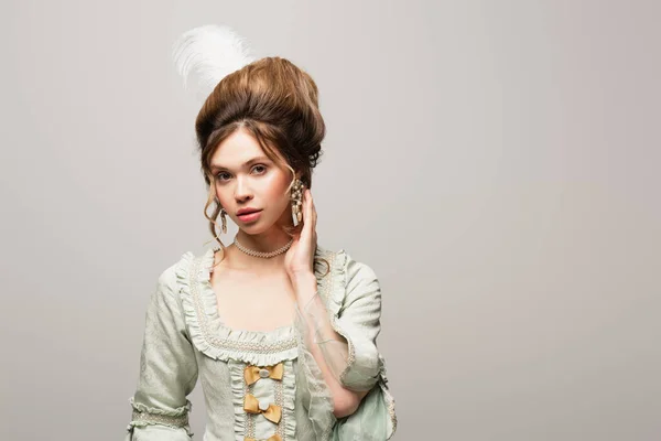 Sensual woman in elegant vintage outfit touching hair while looking at camera isolated on grey — Stock Photo