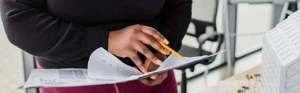 Partial view of african american plus size engineer holding charts and graphs, banner — Stock Photo