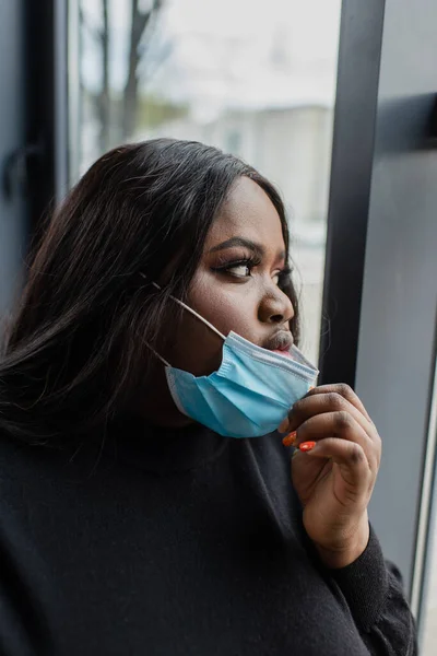 Bruna afro-americana plus size donna d'affari regolazione maschera medica — Foto stock