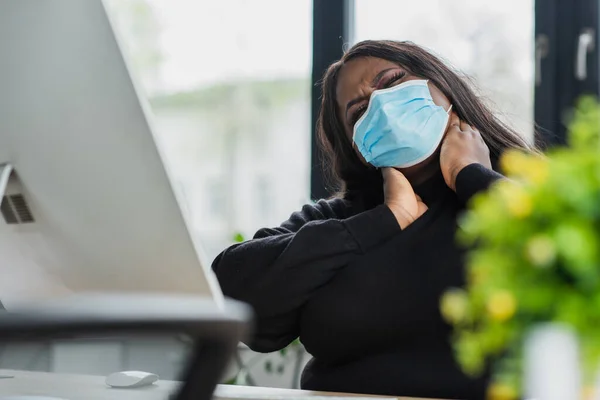 African american plus size businesswoman in medical mask touching neck — Stock Photo