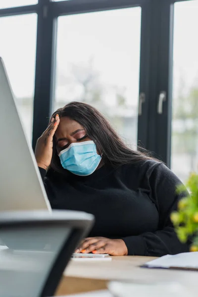 Афроамериканський плюс розмір бізнес-леді в медичній масці страждає від головного болю — стокове фото