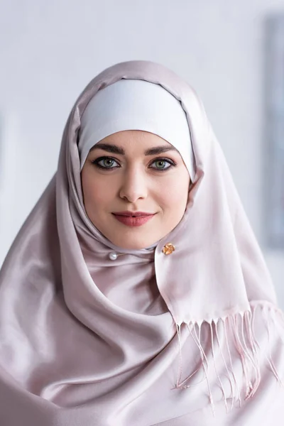 Retrato de mujer bastante musulmana sonriendo mientras mira a la cámara - foto de stock