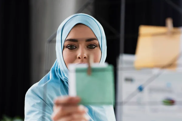 Muslim businesswoman touching paper note on blurred foreground — Stock Photo