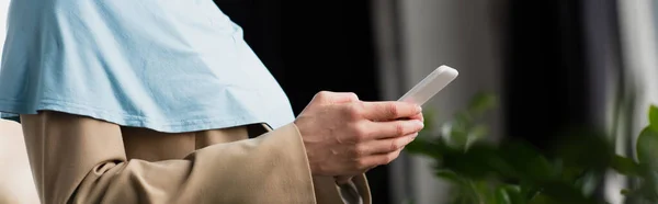 Teilansicht der muslimischen Geschäftsfrau Nachrichten auf dem Handy, Banner — Stockfoto