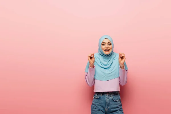 Alegre e animado muçulmano mulher gestos no fundo rosa — Fotografia de Stock