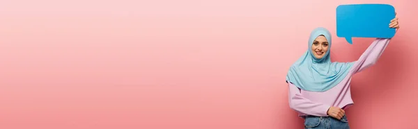 Allegra donna musulmana con bolla vocale guardando la fotocamera su sfondo rosa, banner — Foto stock