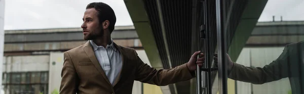 Jovem empresário em blazer porta de abertura, banner — Fotografia de Stock