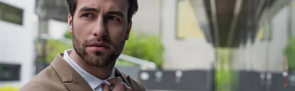 Young worried businessman looking away outside, banner — Stock Photo