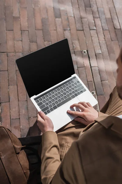 Visão de alto ângulo de homem de negócios digitando no laptop com tela em branco — Fotografia de Stock