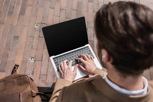 High angle view of blurred businessman typing on laptop with blank screen — Stock Photo