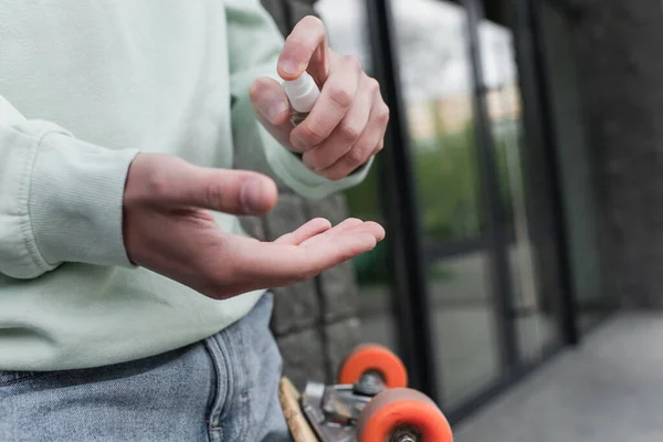 Vista recortada del hombre aplicando desinfectante en la mano - foto de stock