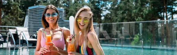 Amis heureux avec des verres à cocktail reposant dans la piscine, bannière — Photo de stock