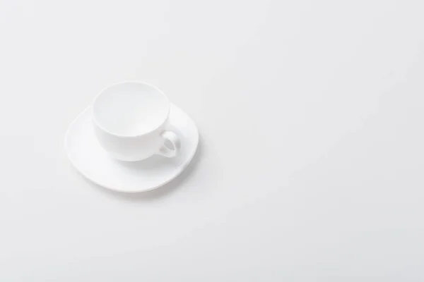 Draufsicht auf leere Keramiktasse und Untertasse isoliert auf Weiß — Stockfoto