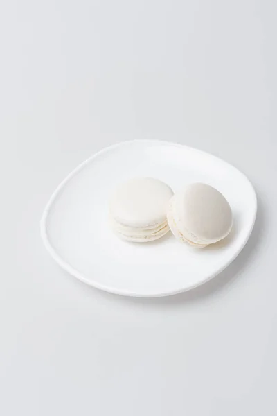 Sweet macarons on plate isolated on white — Stock Photo